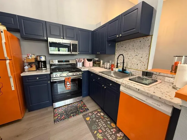 a kitchen with stainless steel appliances granite countertop a stove a sink dishwasher and a refrigerator