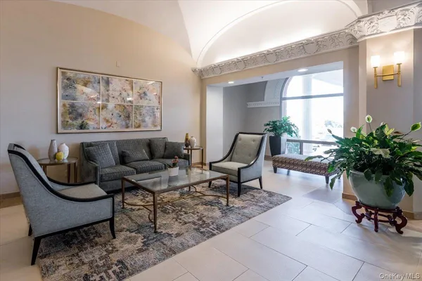 a living room with furniture and a potted plant
