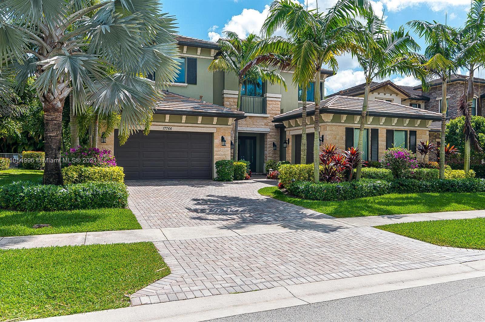 17766 Cadena Drive Boca Raton, FL 33496 - Photo 2 of 28 a front view of a house with a yard and potted plants