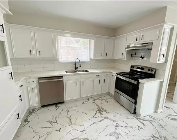 a kitchen with a white cabinets and white appliances