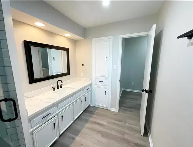 a bathroom with a toilet sink double vanity and mirror