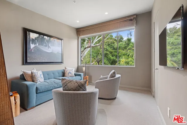 a bedroom with a large bed and a flat tv screen on dresser