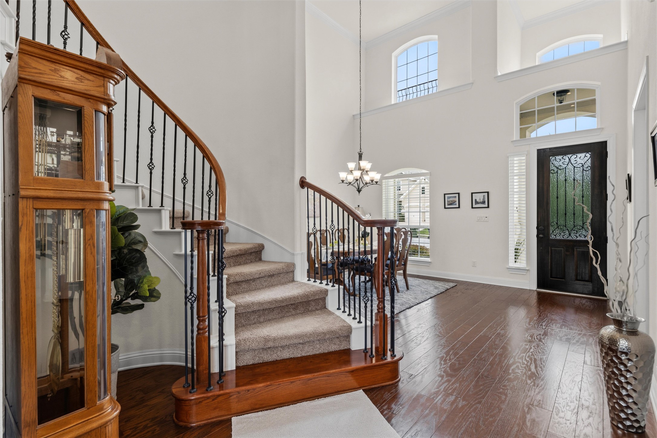 1733 Siena Sunset Road Leander, TX 78641 - Photo 12 of 40 Grand foyer with soaring ceilings, dark wood-finish flooring, and a curved staircase featuring wrought iron balusters and a wood handrail