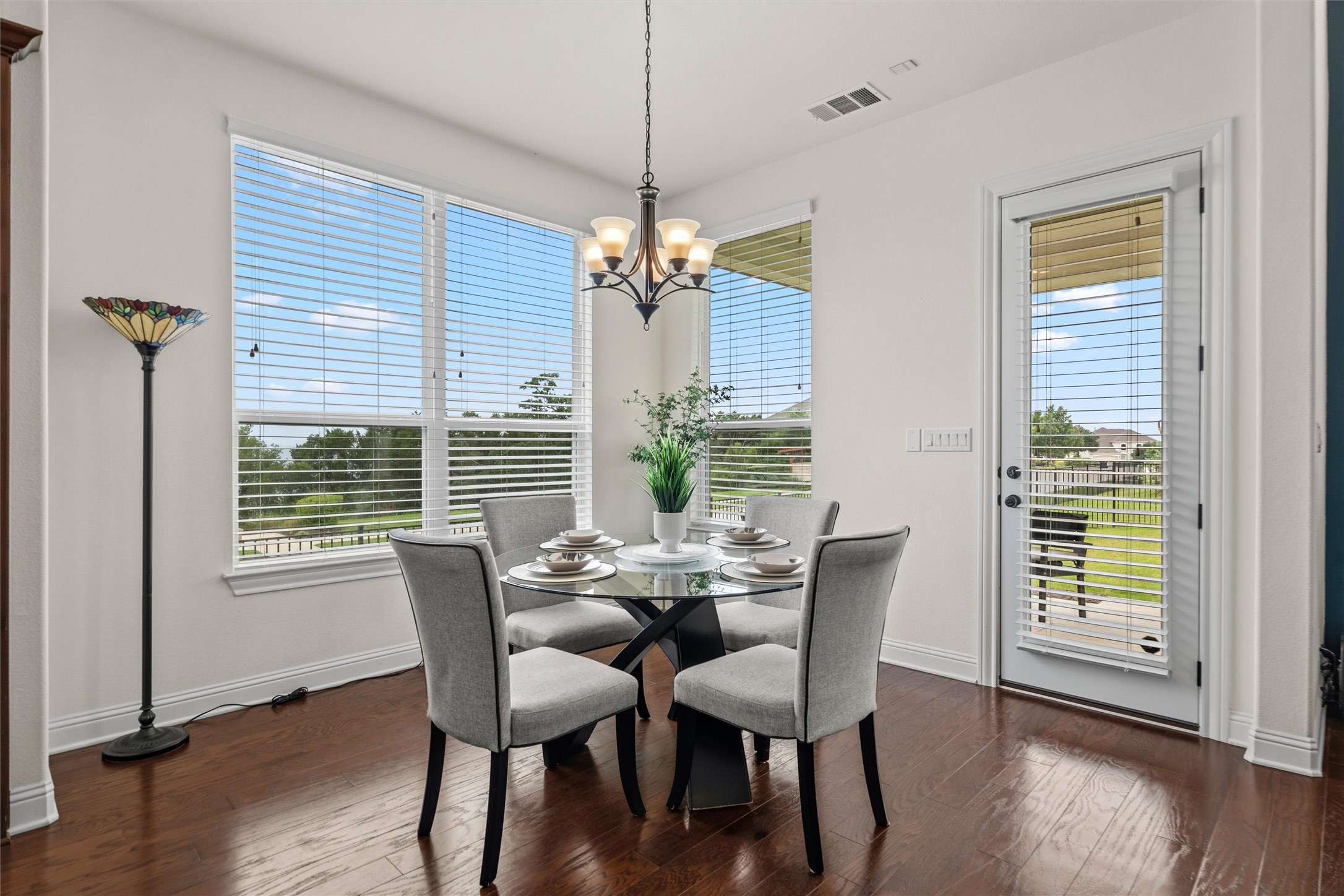 1733 Siena Sunset Road Leander, TX 78641 - Photo 21 of 40 Dining area featuring dark wood-finish flooring, a contemporary chandelier, and a glass-paneled door with great hill country and sunset views