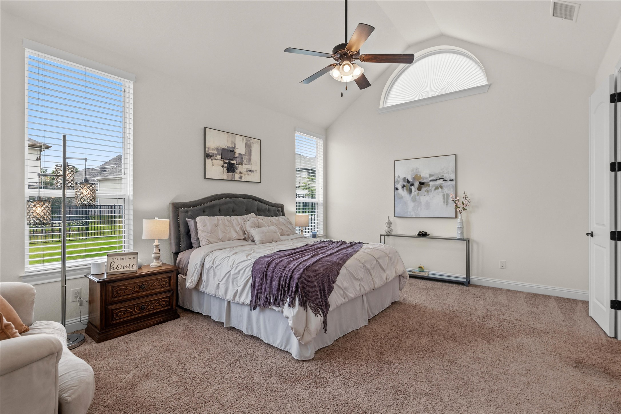 1733 Siena Sunset Road Leander, TX 78641 - Photo 27 of 40 Vaulted ceiling room featuring light-toned carpet flooring, a ceiling fan with integrated lighting, multiple windows with horizontal blinds, and a prominent arched transom window