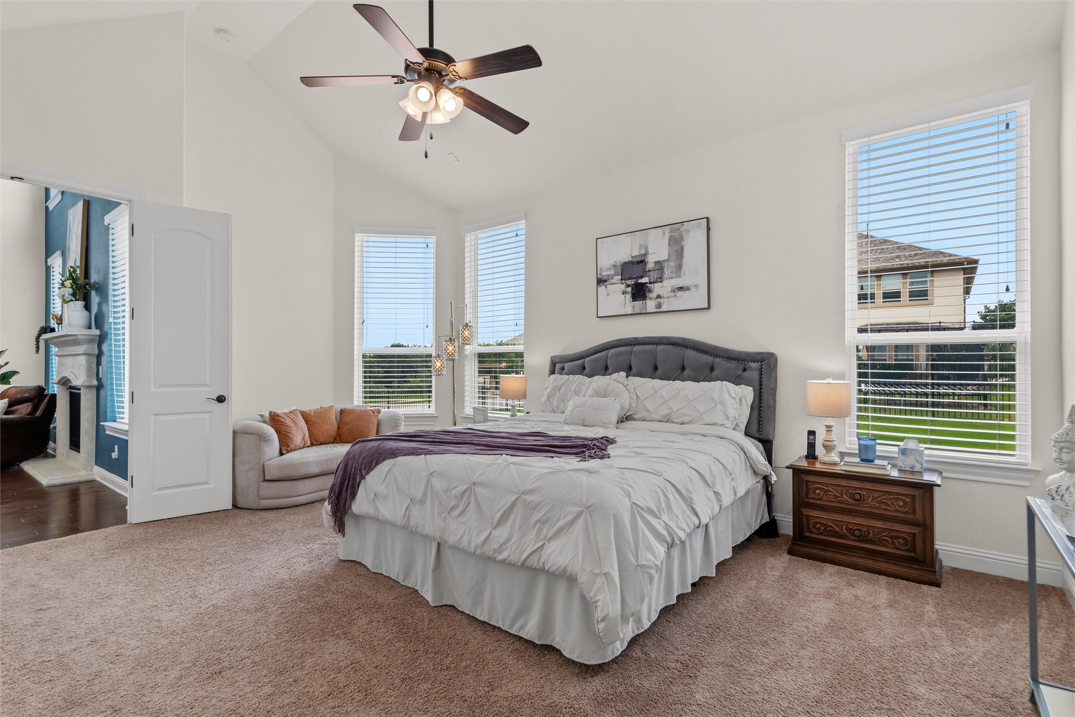 1733 Siena Sunset Road Leander, TX 78641 - Photo 28 of 40 Vaulted ceilings with a ceiling fan, multiple tall windows with blinds, a white paneled door, and neutral-toned carpeting