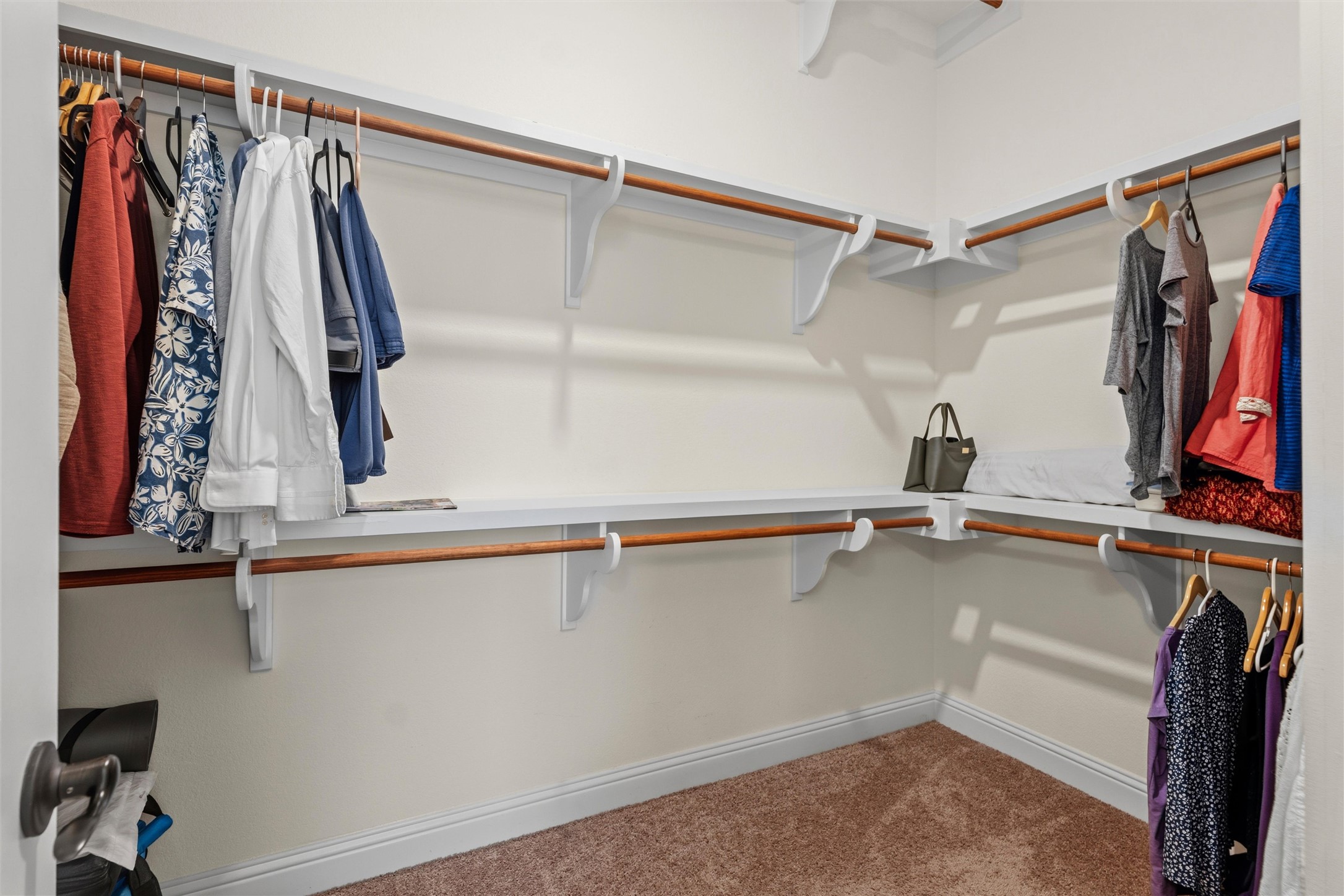 1733 Siena Sunset Road Leander, TX 78641 - Photo 31 of 40 Walk-in closet featuring carpet flooring, crisp white walls, white shelving, and wood-finish hanging rods