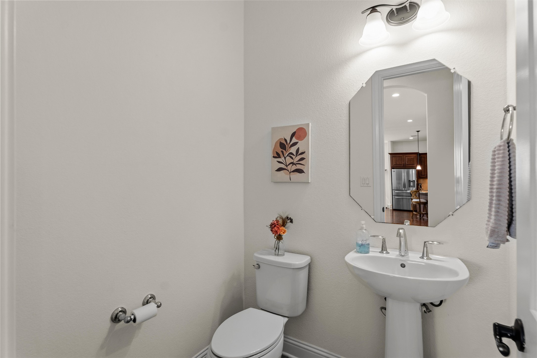 1733 Siena Sunset Road Leander, TX 78641 - Photo 33 of 40 Pedestal sink with chrome faucet, octagonal mirror, and a two-bulb vanity light fixture