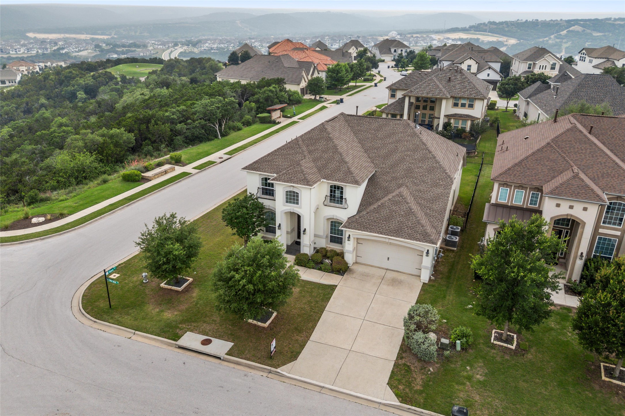 1733 Siena Sunset Road Leander, TX 78641 - Photo 8 of 40 Two-story stucco residence featuring a prominent front-facing three-car garage, an arched entryway, and multiple window styles including arched and rectangular designs