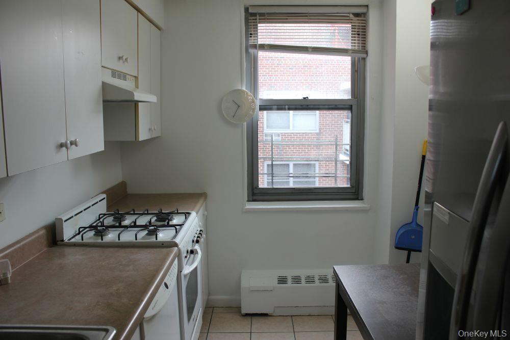 61-25 97th Street, Unit 15J Queens, NY 11374 - Photo 11 of 17 a kitchen that has a stove and a window