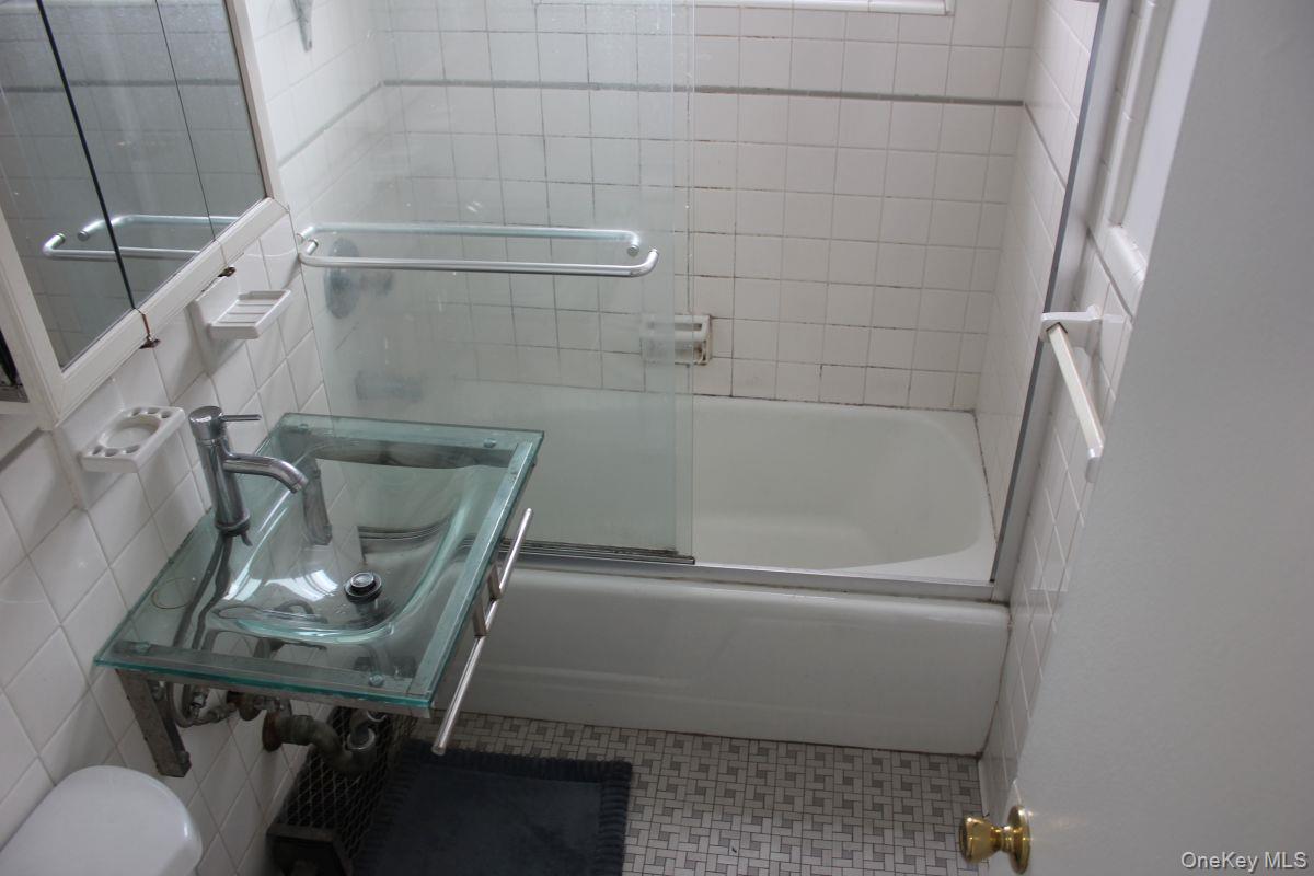 61-25 97th Street, Unit 15J Queens, NY 11374 - Photo 14 of 17 a bathroom with a sink toilet and shower