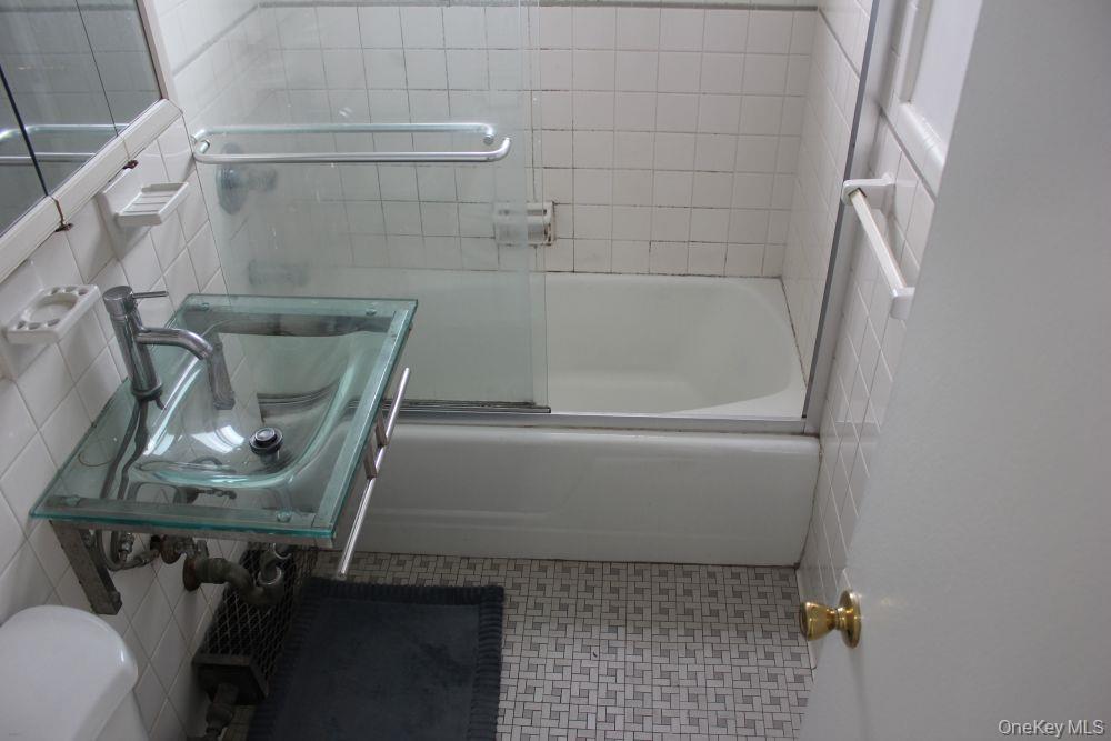 61-25 97th Street, Unit 15J Queens, NY 11374 - Photo 15 of 17 a bathroom with a sink and mirror