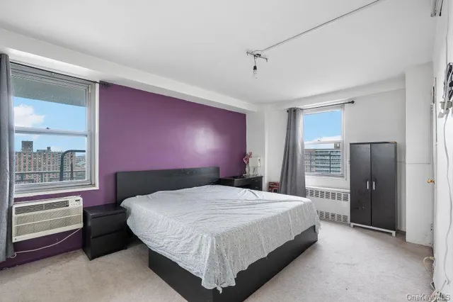 a bedroom with a bed and a refrigerator