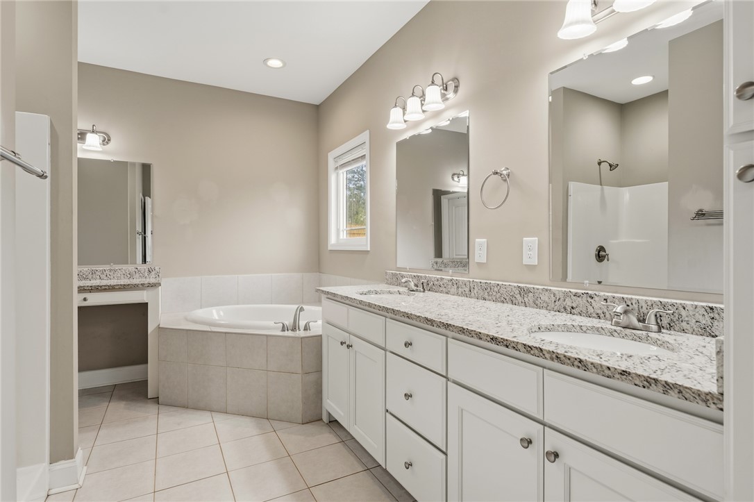 1411 Dunn Road Anderson, SC 29625 - Photo 18 of 30 This spacious primary bathroom features a dual vanity, a soaking tub, and a shower.