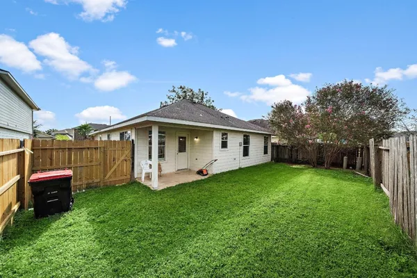 a front view of house with yard and trees in the background