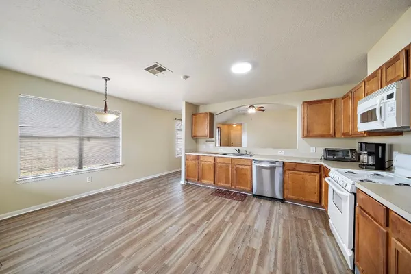 a large kitchen with a wooden floor and a large window