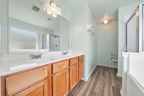 a bathroom with a sink a mirror a vanity and a shower