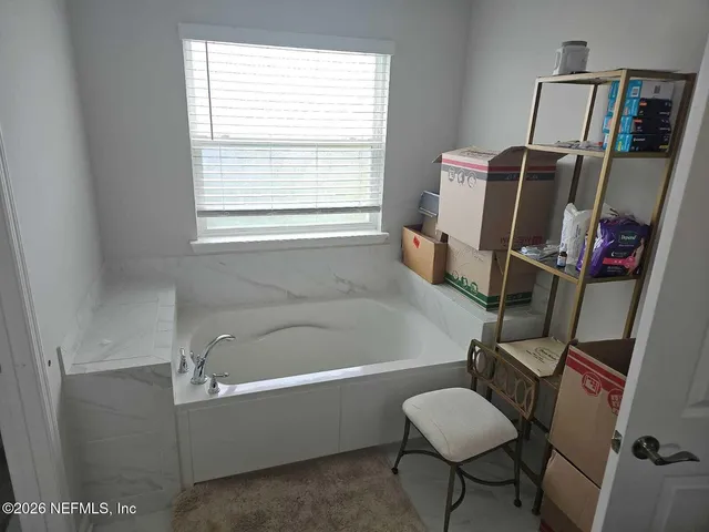 a bathroom with a tub sink and a window