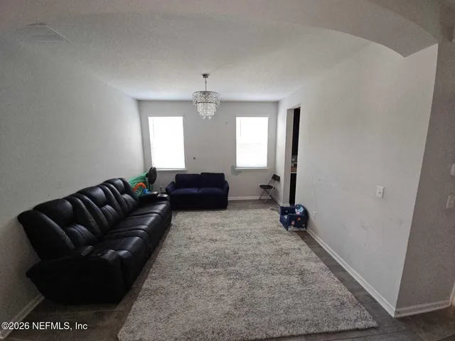 a living room with furniture and a chandelier