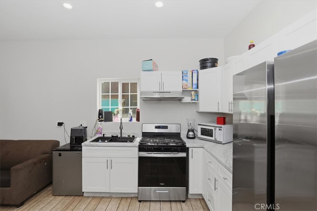 245 Commercial Avenue Riverside, CA 92507 - Photo 12 of 30 a kitchen with stainless steel appliances a stove a refrigerator and a sink