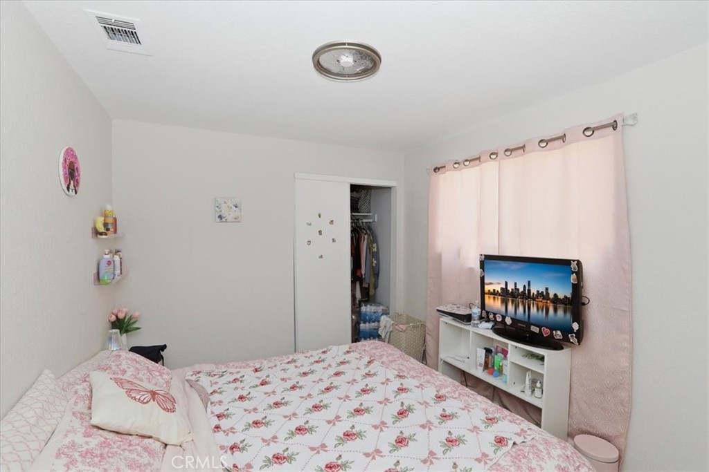 245 Commercial Avenue Riverside, CA 92507 - Photo 17 of 30 a bedroom with a bed and a flat screen tv