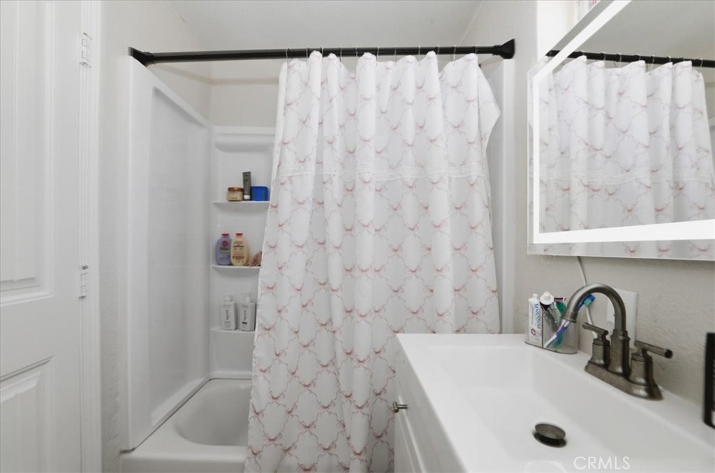 245 Commercial Avenue Riverside, CA 92507 - Photo 19 of 30 a bathroom with a sink and a shower curtain