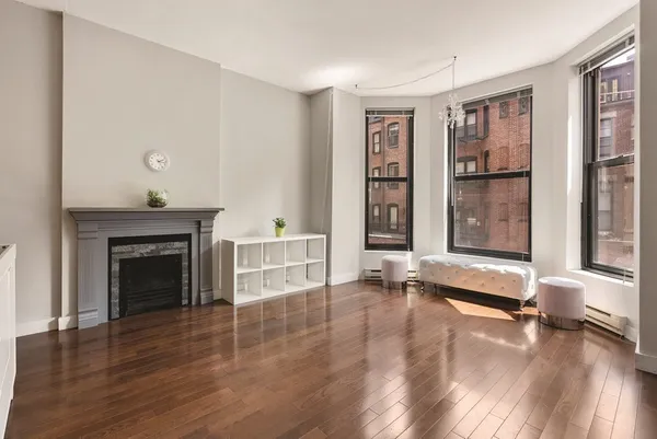 wooden floor fireplace and windows in an empty room