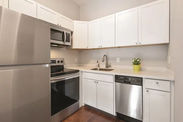 a kitchen with cabinets stainless steel appliances and sink