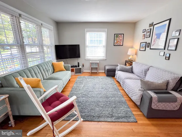 a dining room with furniture a chandelier and wooden floor