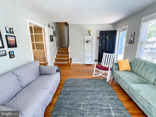 a dining room with wooden floor a chandelier a wooden table and chairs