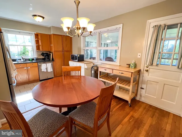 a dining room with furniture a chandelier and wooden floor