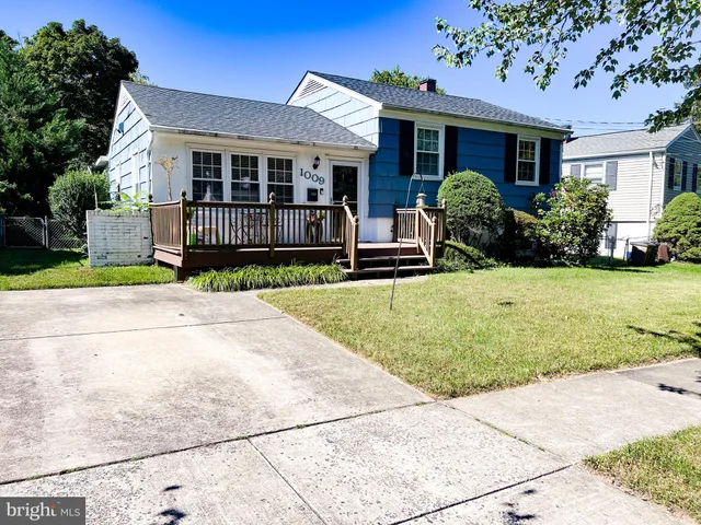 a view of a house with a porch next to a yard