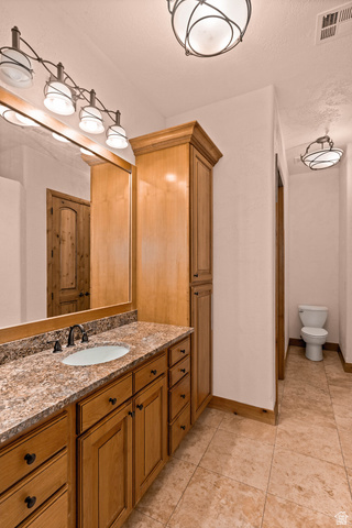 2464 East Granite Way St. George, UT 84790 - Photo 68 of 106 Bathroom with vanity, light tile patterned flooring, and a textured ceiling