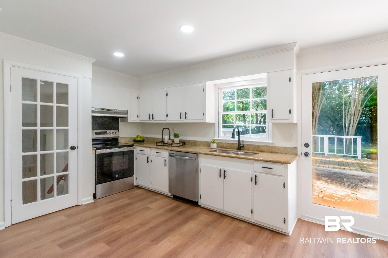 115 Pineridge Road Daphne, AL 36526 - Photo 13 of 34 Kitchen with under cabinet range hood, a sink, crown molding, appliances with stainless steel finishes, and white cabinetry