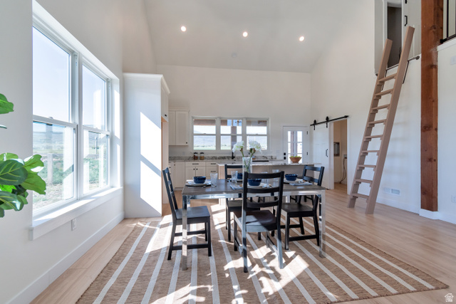 1820 West Farmhouse Flats Road Peoa, UT 84061 - Photo 64 of 79 Open-concept dining area featuring vaulted ceilings, wood-finish flooring, recessed lighting, and expansive windows