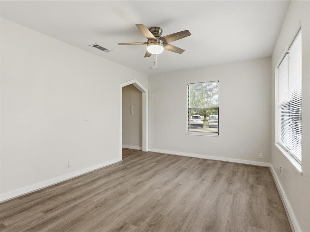 632 North Stewart Street Azle, TX 76020 - Photo 8 of 26 Empty room with ceiling fan, light wood finished floors, and arched walkways