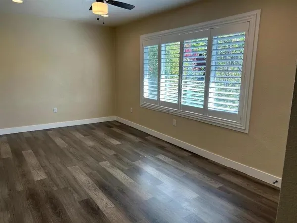 a view of a room with wooden floor and windows
