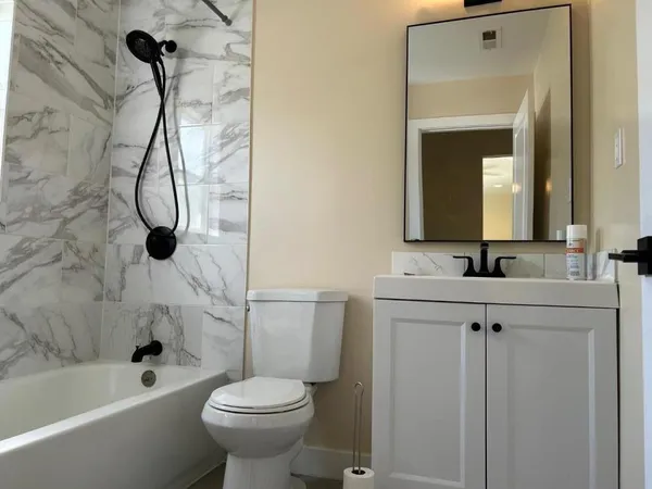 a bathroom with a sink a toilet and shower