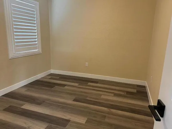 a view of a room with wooden floor and a window