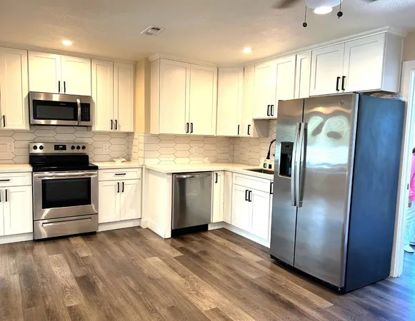 a kitchen with stainless steel appliances a refrigerator sink and microwave