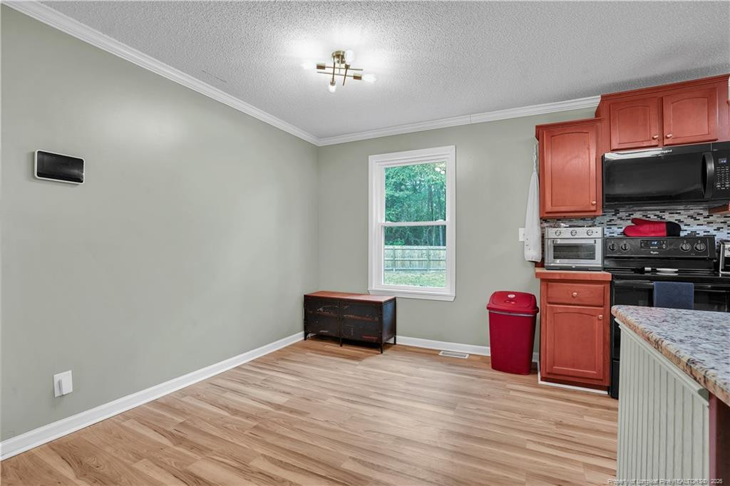 8155 Arabia Road Lumber Bridge, NC 28357 - Photo 14 of 30 a living room with stainless steel appliances kitchen island granite countertop furniture a flat screen tv and a window