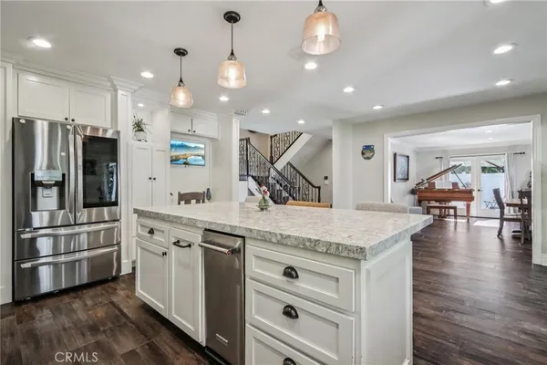 a kitchen with stainless steel appliances granite countertop a sink a stove and a refrigerator