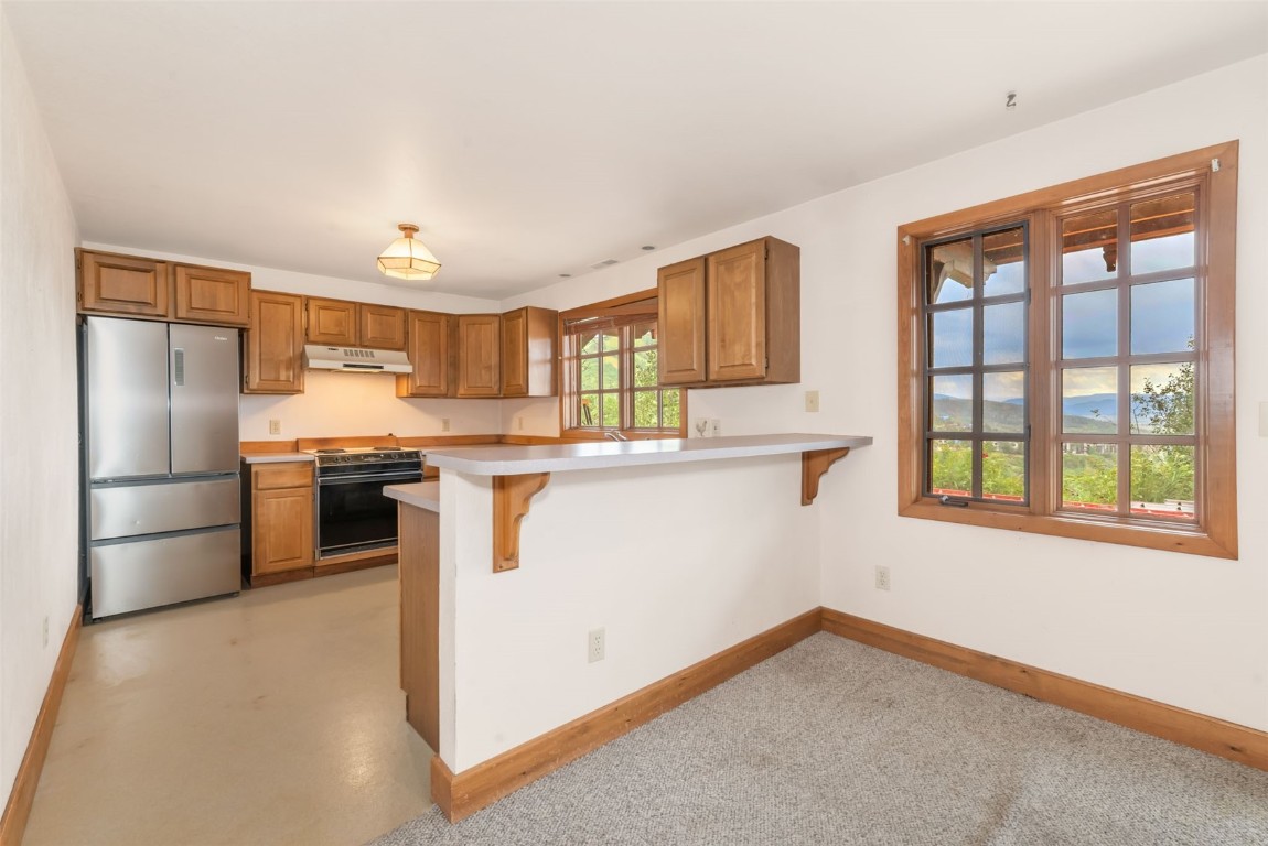 2300 Glacier Ridge Steamboat Springs, CO 80487 - Photo 44 of 50 a kitchen with stainless steel appliances granite countertop a refrigerator a stove and a sink with large window