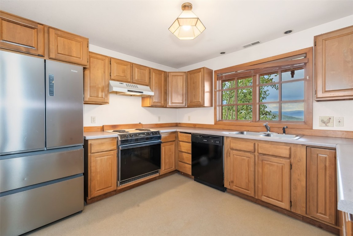 2300 Glacier Ridge Steamboat Springs, CO 80487 - Photo 45 of 50 a kitchen with stainless steel appliances granite countertop a refrigerator a sink dishwasher a stove and white cabinets with wooden floor
