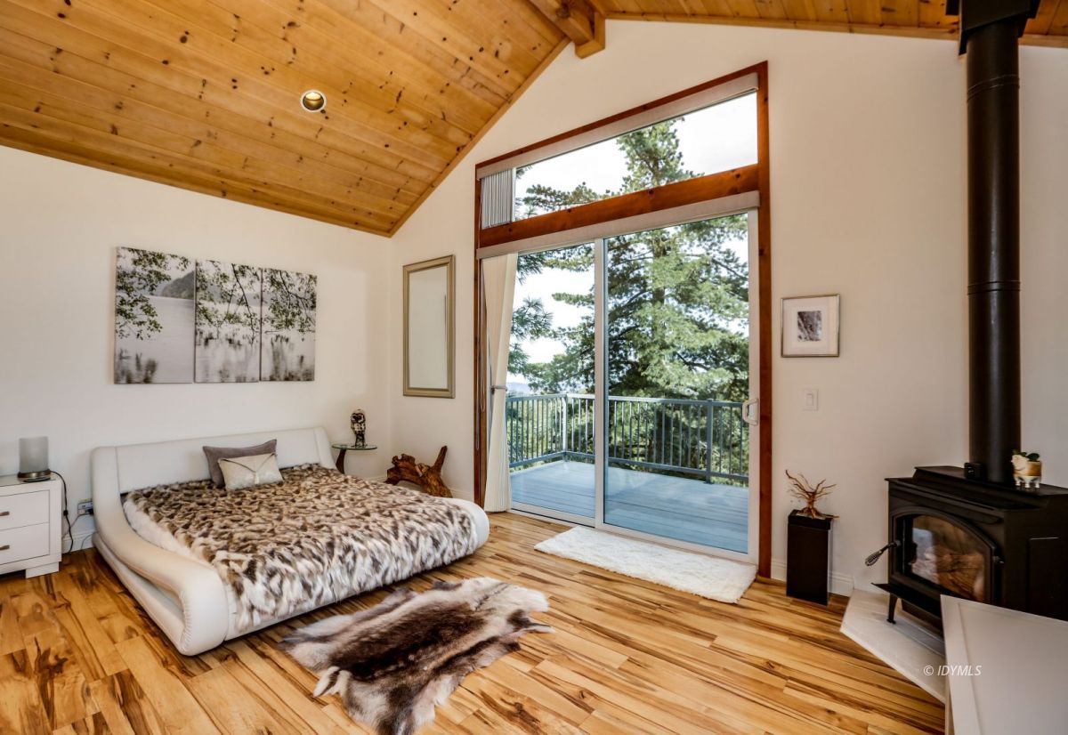 25126 Cougar Road Idyllwild, CA 92549 - Photo 20 of 63 a bedroom with a bed and wooden floor