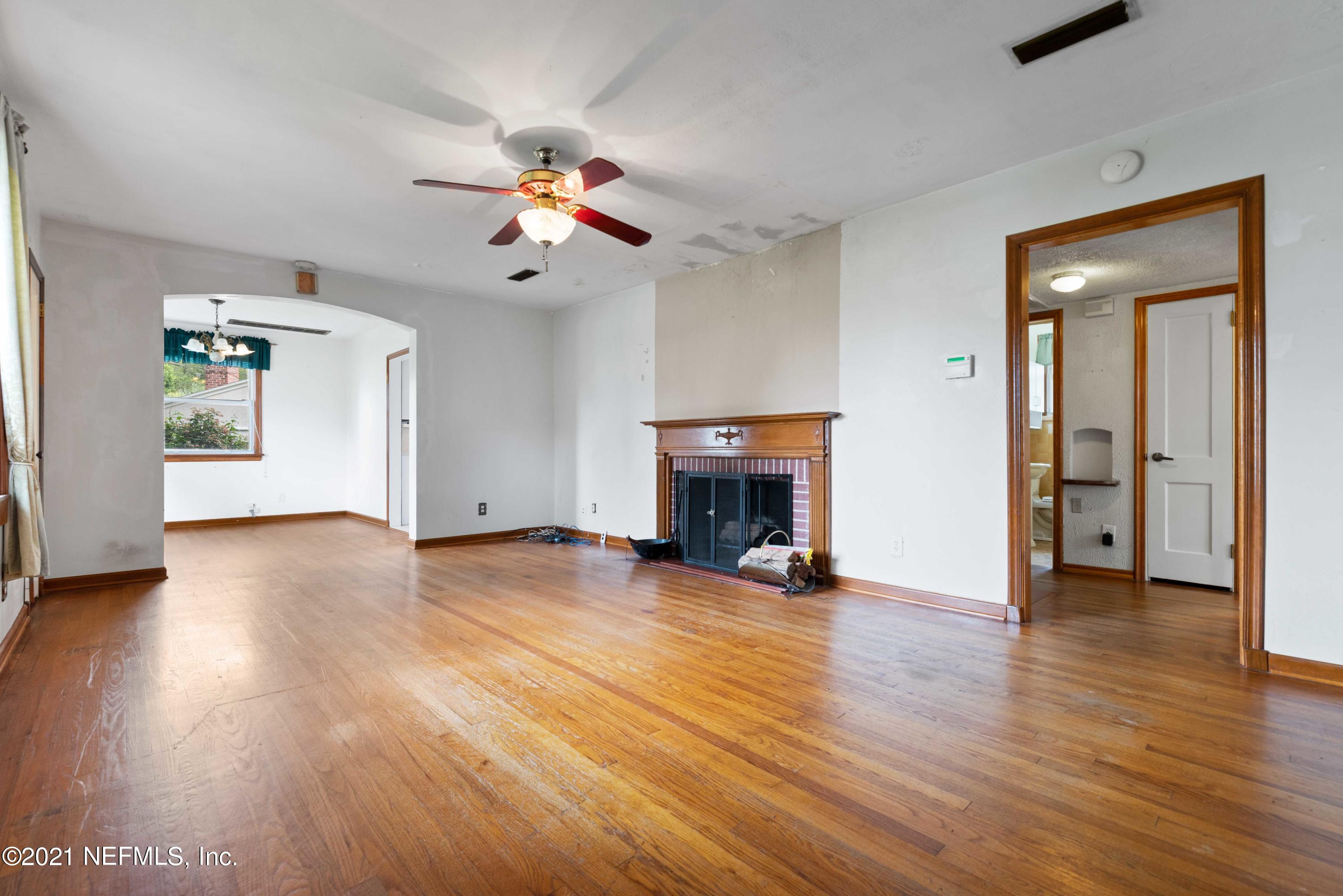 1624 Mayfair Road Jacksonville, FL 32207 - Photo 5 of 23 an empty room with wooden floor a ceiling fan and windows