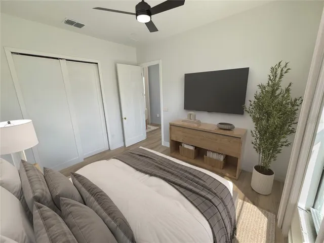 a bedroom with a bed lamp and a large window