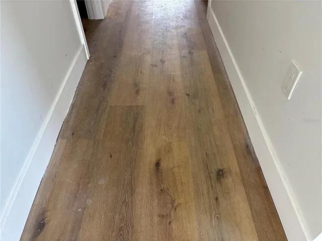 a living room with furniture a fireplace and a dining table with wooden floor