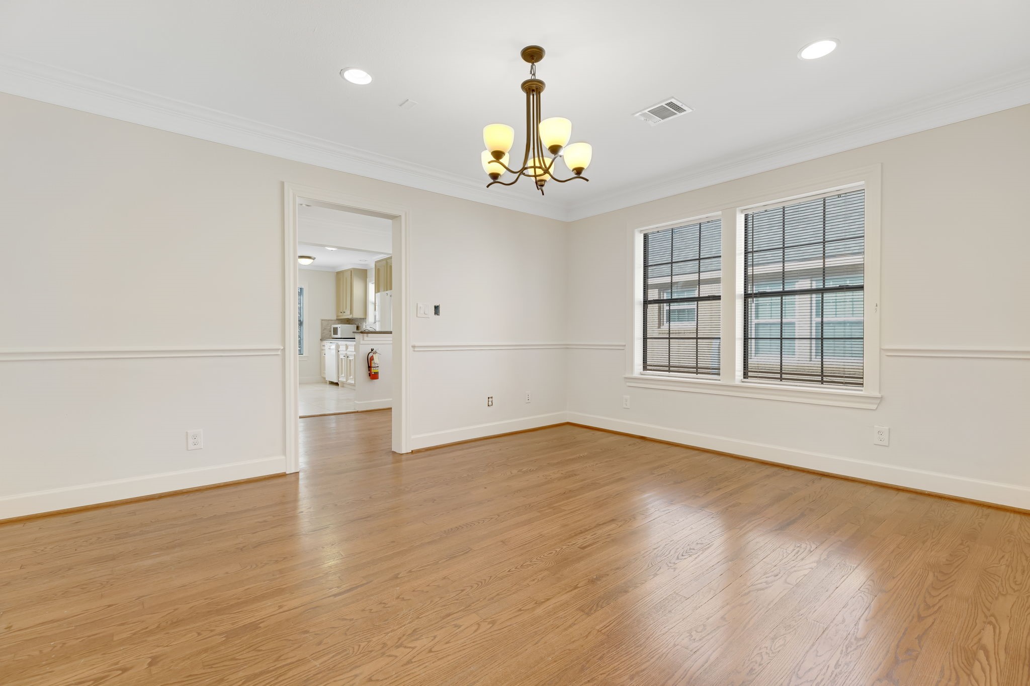 2306 Blodgett Street, Unit 2 Houston, TX 77004 - Photo 4 of 12 an empty room with wooden floor chandelier and windows