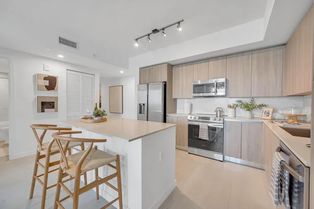 a kitchen with stainless steel appliances granite countertop a stove top oven a sink dishwasher and a refrigerator